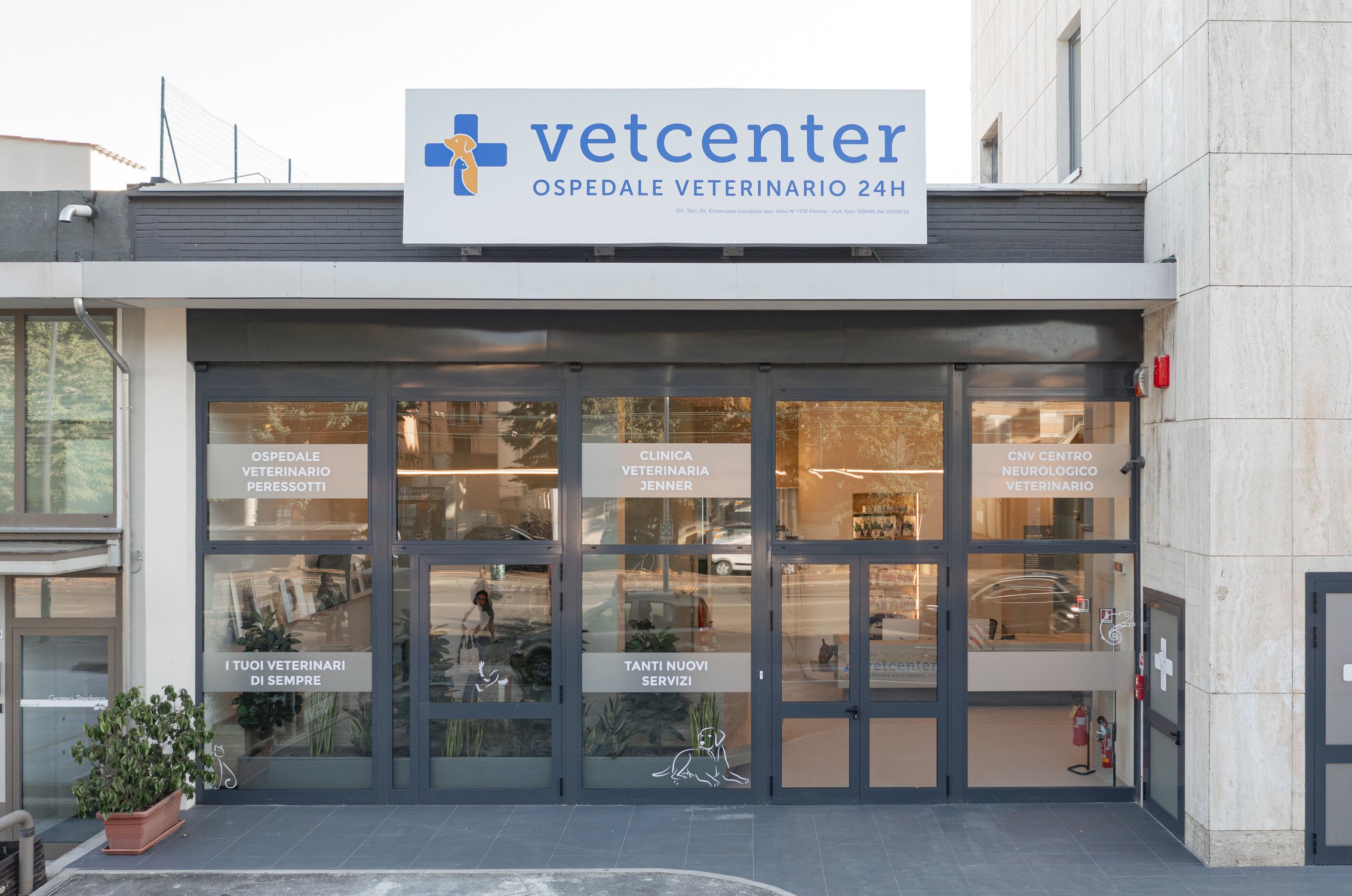 Foto dell'ingresso dell'Ospedale Veterinario 24H VetCenter di Parma dove si vedono l'insegna e delle vetrofanie